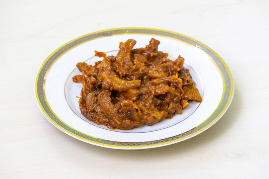 Homemade elephant apple pickle (chalta achar) served on a white plate. This pickle offers a delicious blend of sour, spicy, and sweet flavors.