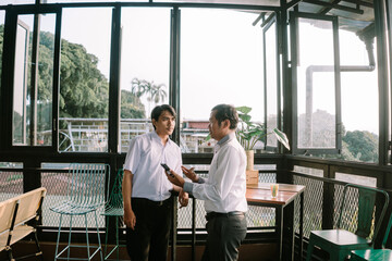 Two Southeast Asian men engaging in an enthusiastic conversation