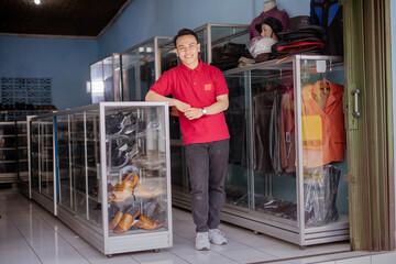 full body picture of asian entrepreneur standing and leaning in shoes shelf with folded hand