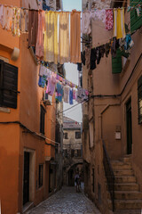 Obraz premium Charming Rovinj alley adorned with vibrant laundry under the warm Croatian sun