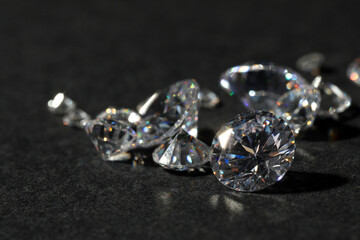 Many beautiful shiny diamonds on black table, closeup