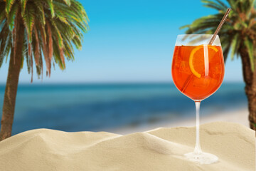 Summer beach with delicious Aperol Spritz cocktail, palm trees and golden sand, space for text