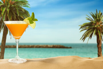 Summer beach with delicious cocktail, palm trees and golden sand, space for text