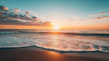 Fototapeta premium A stunning sunset over a tranquil beach, with the sun dipping below the horizon and plenty of open sky for text.
