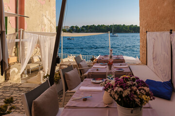 Relaxing dinner setup overlooking the serene waters of Rovinj, Croatia during the golden hour