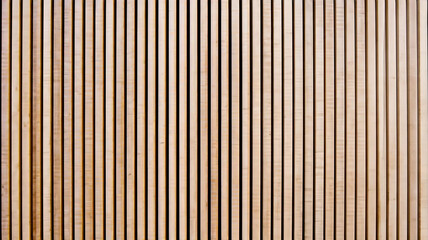 Obraz premium Wall made of wooden panels. Vertical wooden slats for facade cladding. Timber stripes made of beige pine. A modern plank surface for interior and exterior design.