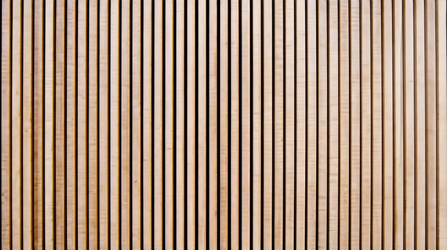 Wall made of wooden panels. Vertical wooden slats for facade cladding. Timber stripes made of beige pine. A modern plank surface for interior and exterior design.