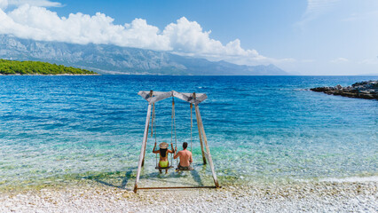 Relaxing moments on the swing by the stunning Brac Island shore in Croatia under a sunny sky