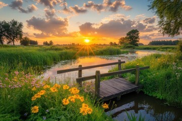 A serene sunset over a tranquil river with flowers and a wooden bridge.