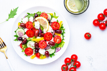 Greek salad with vegetables, cheese and lettuce, white background, top view
