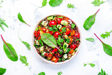 Quinoa vegan salad with avocado, tomatoes, onion and parsley, white background, top view