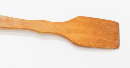 A close up of wooden spatula with rectangular blade, showcasing its natural grain texture.