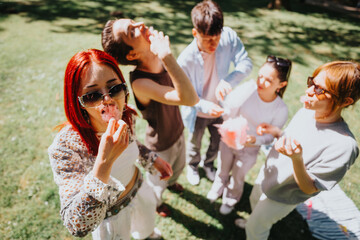 Joyful friends enjoying cotton candy together in a sunny park