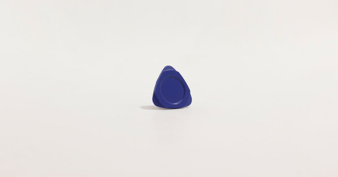 Minimalist photo of small, blue, triangular phone pry tool with circular center on plain white background.