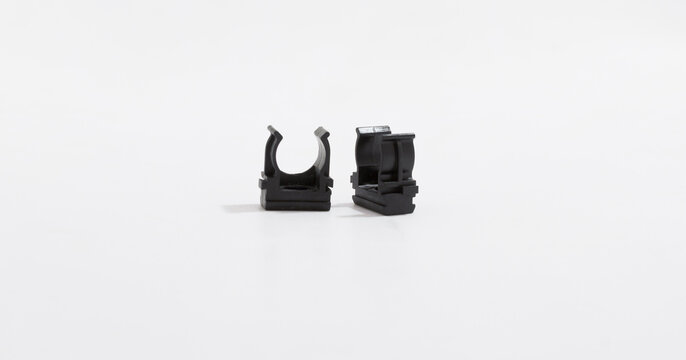Black plastic clips, fasteners for securing cables, wires, or tubes, displayed on plain white background.