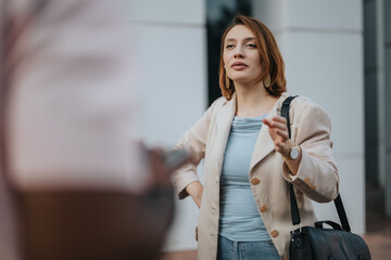 A confident woman participates in an outdoor business meeting. She appears engaged, standing in front of a modern building, conveying professionalism and leadership.