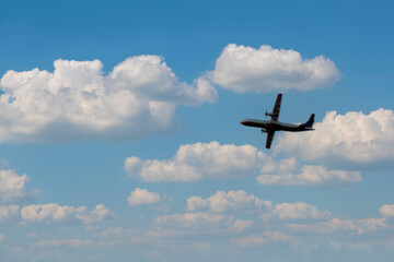 An aircraft soars through the sky against a backdrop of fluffy clouds, capturing the essence of aviation and freedom. The perfect representation of travel, exploration, and the thrill of flight.


