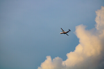 An aircraft soars through the sky against a backdrop of fluffy clouds, capturing the essence of...