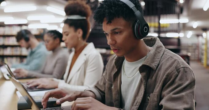 Man, student and headphones with laptop in library for typing assignment essay, study music or exam research. University, group and person with technology for online course, radio audio and education