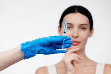 Woman while procedure lip augmentation at cosmetology clinic with beautician. Filler injection for...