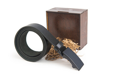 Black leather belt twisted into a ring, packing wooden box