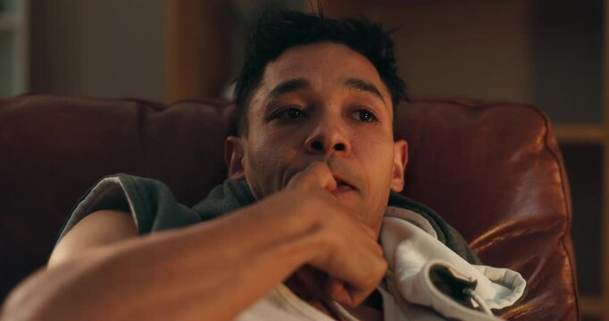 Man, biting nails and stress in home on sofa, panic and withdrawal symptoms with addiction at night. Person, paranoid and thinking with anxiety, frustrated and mental health with substance abuse