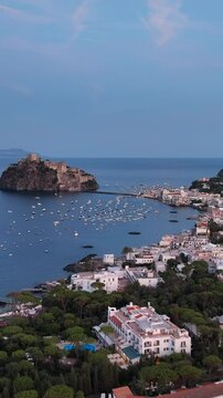 Ischia, Golfo di Napoli, Italia, l'isola con il castello Aragonese.
Vista aerea da drone, Composizione verticale, dell'isolotto di Ischia.