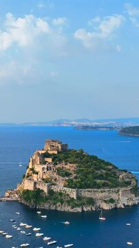 Ischia, Golfo di Napoli, Italia, l'isola con il castello Aragonese.
Vista aerea da drone, Composizione verticale, dell'isolotto di Ischia.