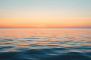 Fototapeta premium Calm Ocean Surface at Sunset with a Soft Pink and Orange Sky