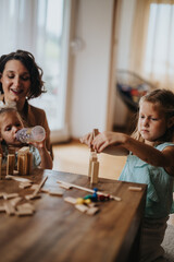 A mother with her daughters playing and building with wooden blocks at home, creating a warm, family atmosphere of joy and learning.