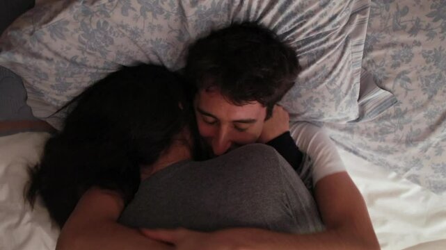 Couple embracing in bed, with the man resting his face against the woman. tender moment captures a sense of intimacy and warmth, comfort and closeness in a serene bedroom setting