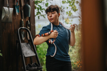 A young girl confidently handles colorful snakes in an outdoor setting, showcasing bravery and...