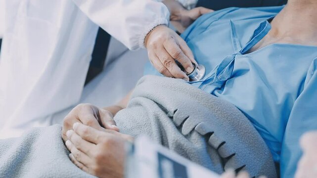 A doctor examining a middle-aged male patient in a coma in a hospital bed