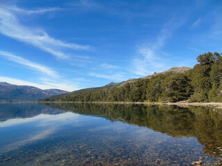 Fototapeta premium Idyllic view of Meliquina Lake with mountains reflecting in its crystal clear waters,