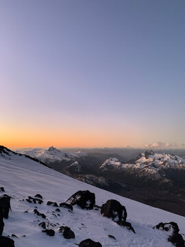Dawn at the slopes of Lanin Volcano during ascent to its mountain top. Colourful sky and snow-capped Andes Mountains as backdrop.