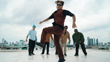 Professional asian street dancer practice B boy dance while multicultural friends at roof top....