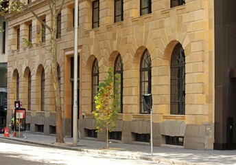 Obraz premium Front of a historic sandstone building with arched widows