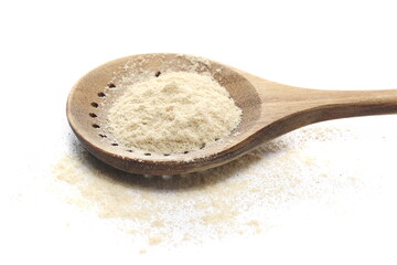 Sesame flour pile in wooden spoon isolated on white, side view