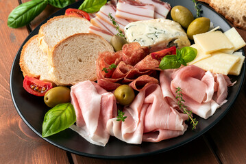 Piatto di salumi, prosciutti e formaggi italiani, gastronomia europea 