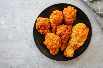 Crispy Fried chicken in  black plate  on grey background , top view food table with free copy space