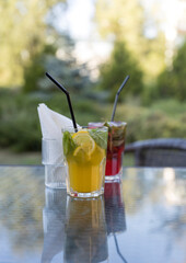 Two glasses of drinks with straws on top of them