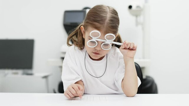 A young girl is practicing her vision skills in a state-of-the-art ophthalmology clinic. Engaging tools and a friendly atmosphere make the experience both fun and beneficial for her development.