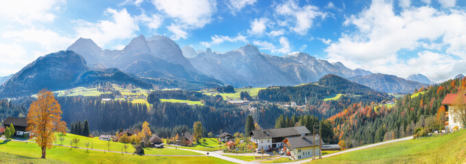 Captivating view of  Alpine green fields and traditional wooden houses near Abtenau village at autumn sunny day.