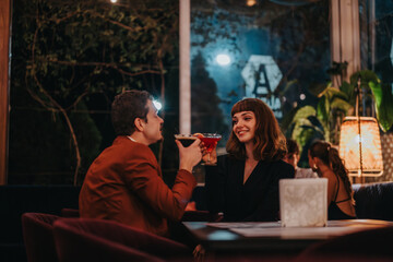 A couple enjoys cocktails in a warmly lit restaurant, creating a romantic and intimate atmosphere. The night scene highlights their joyful interaction and relaxed mood.