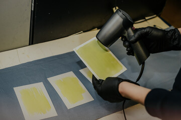 Photographer working in a lab creating custom cyanotype prints on craft paper. Chemicals, tools, and UV light exposure to develop unique, handcrafted blue-toned printmaking techniques