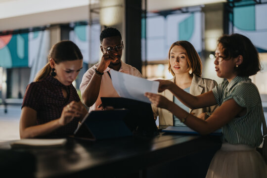 A group of diverse business professionals collaborating on a project in an urban city environment. The team exhibits teamwork, communication, and modern business strategies in a dynamic workplace.