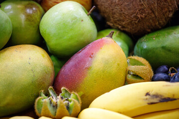 assorted fruits coconut, apple, papaya, grape, kiwi, orange at a street market stall in Rio de Janeiro.