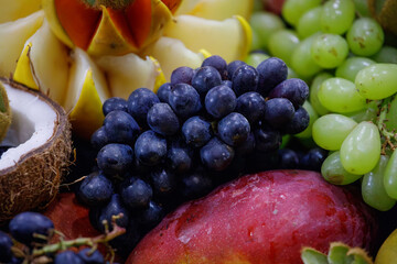 assorted fruits coconut, apple, papaya, grape, kiwi, orange at a street market stall in Rio de Janeiro.