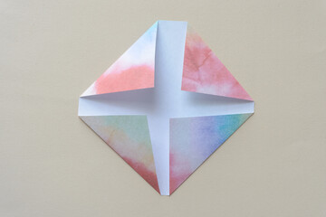 folded paper objects featuring dyed paper rainbow patterns