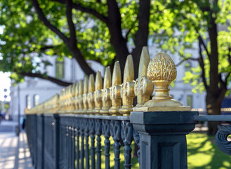 ?ast iron fence with decorative gold finials on a street in St. Petersburg.